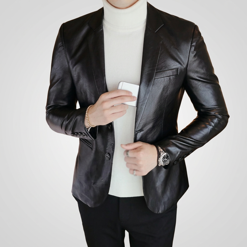 Man wearing a black two-button leather blazer over a white roll-neck on a light grey studio background