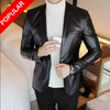 Person wearing a black leather jacket over a white turtleneck in an indoor setting.